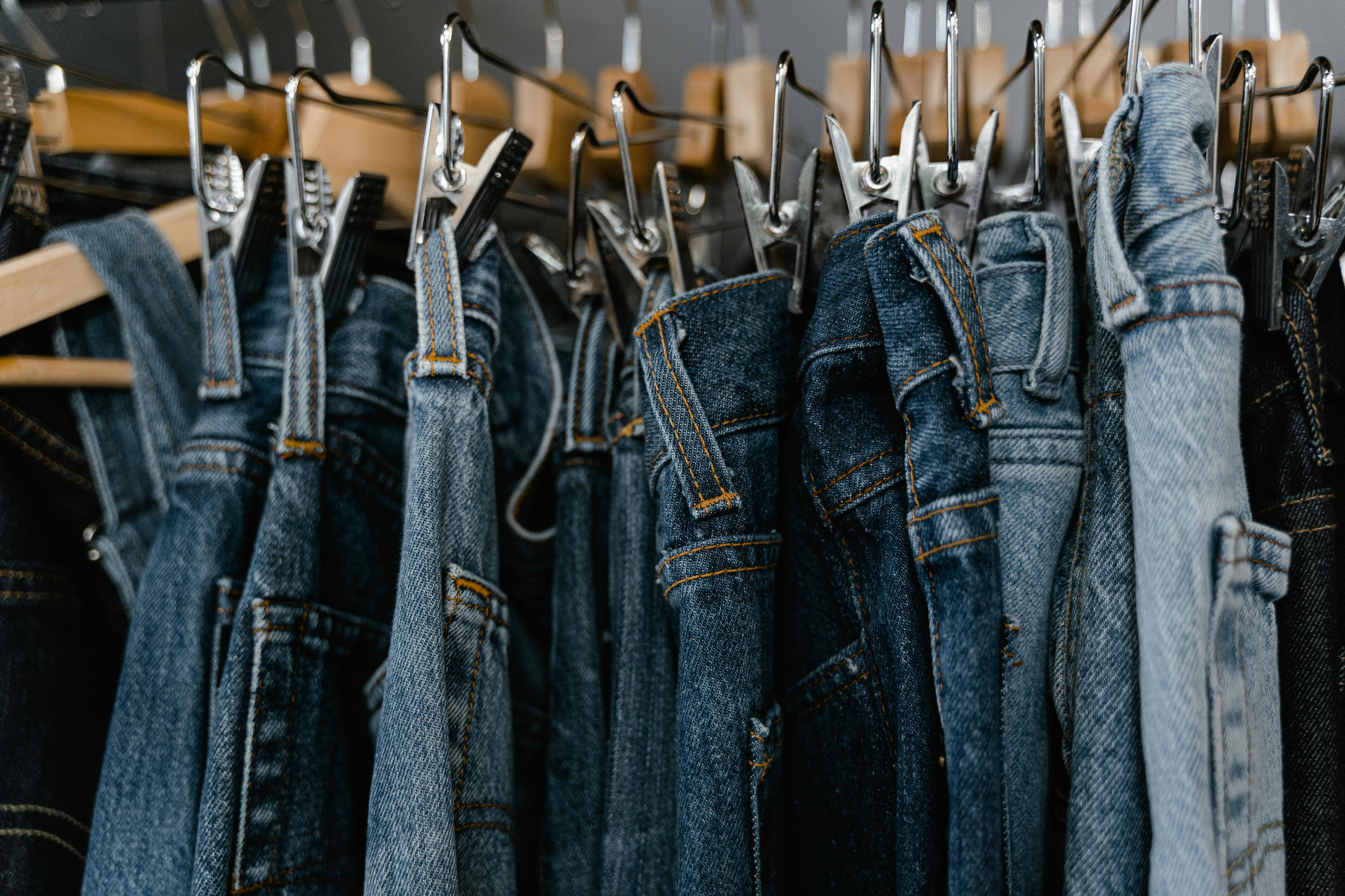 Vintage denim på bøjler i secondhand butik